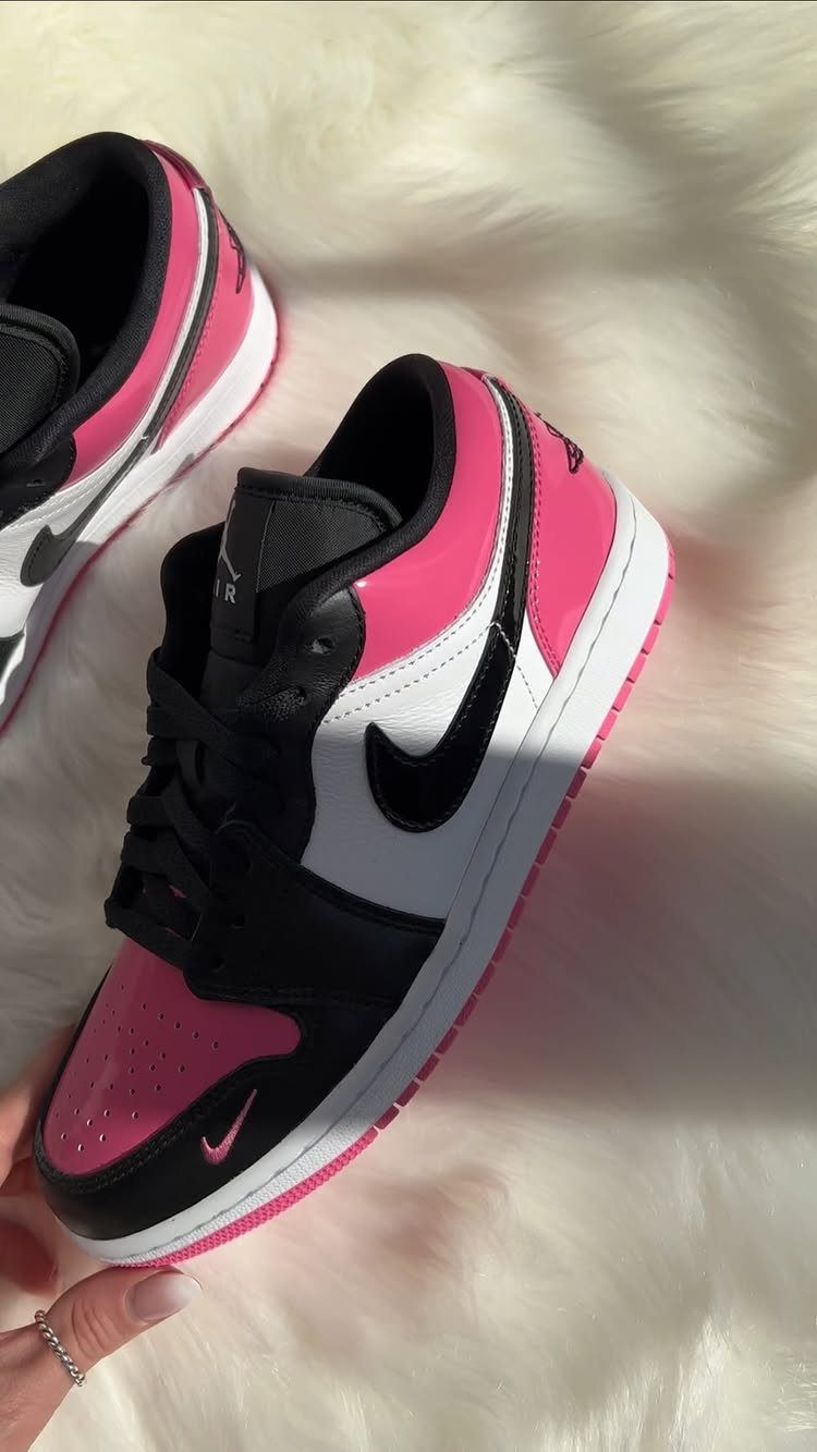 Nike sneakers in black, white, and bright pink on white faux fur
