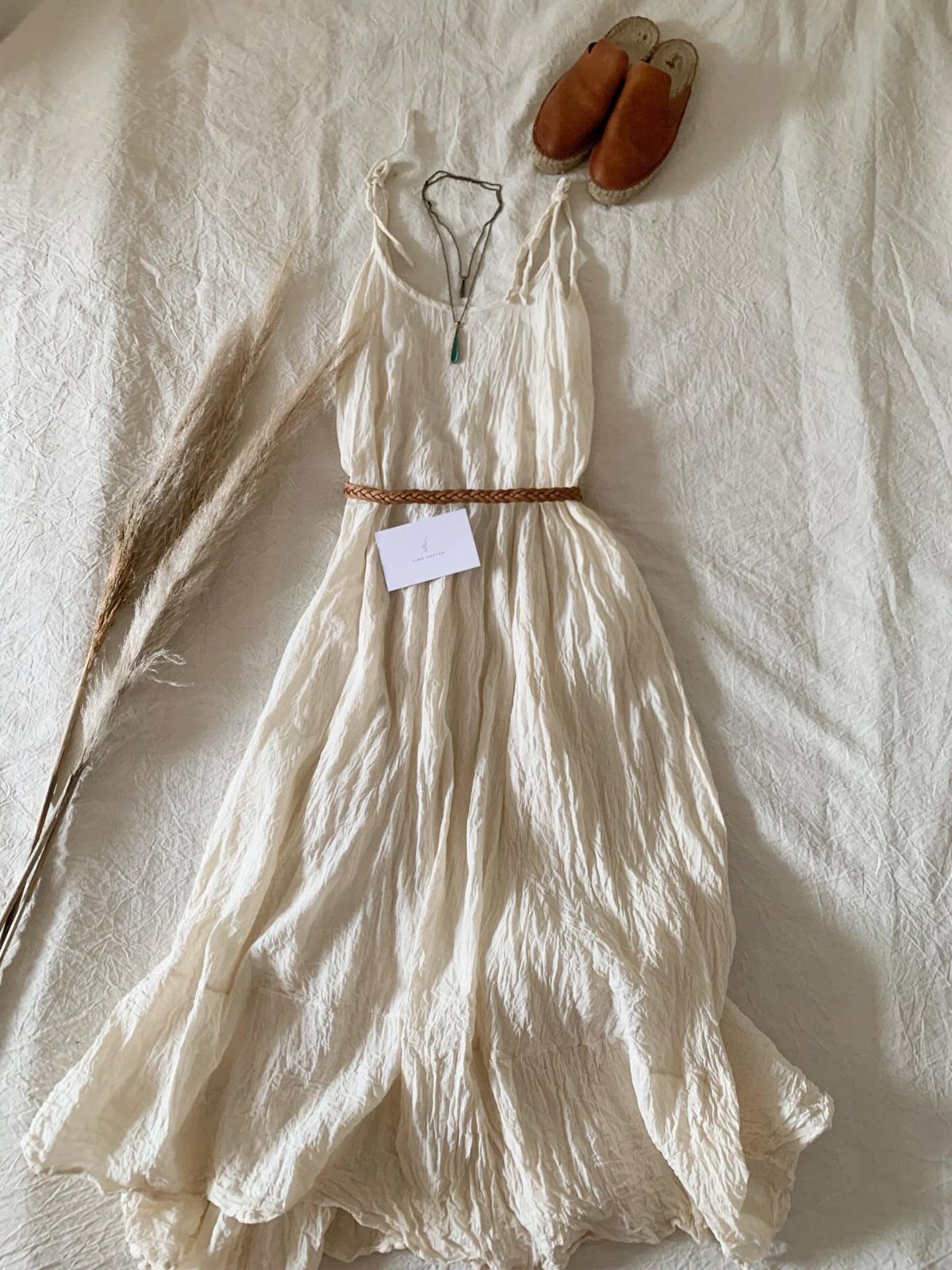7 Off White Boho Dress Ideas for Every Occasion 1 White bohemian maxi dress with a brown belt and leather mules on white fabric
