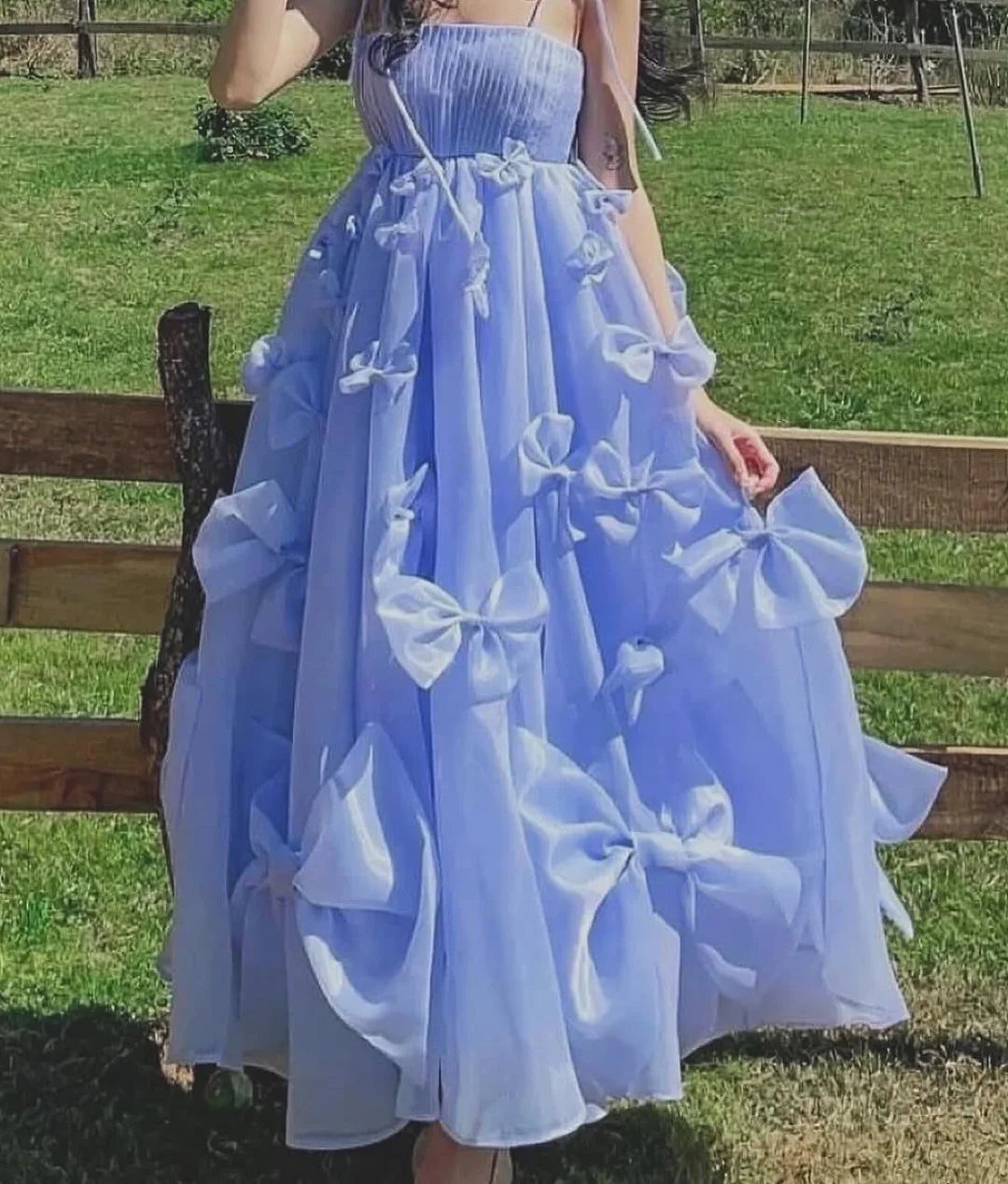 Pink and Blue Dresses: 7 Ideas for Every Style 1 Light blue sleeveless tulle dress with large bows on the skirt in a field