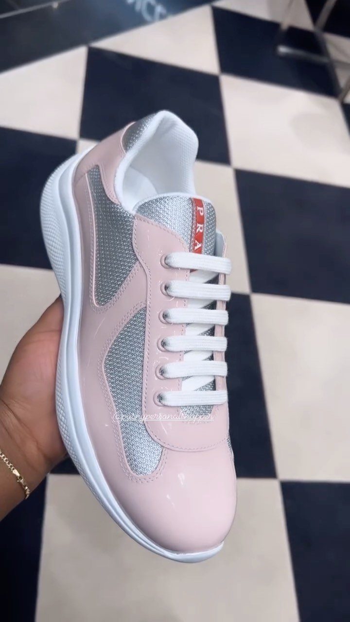 Pink and White Designer Sneakers: 5 Pairs for Women 5 Pink and silver Prada America's Cup Biker sneakers held against checkered flooring.