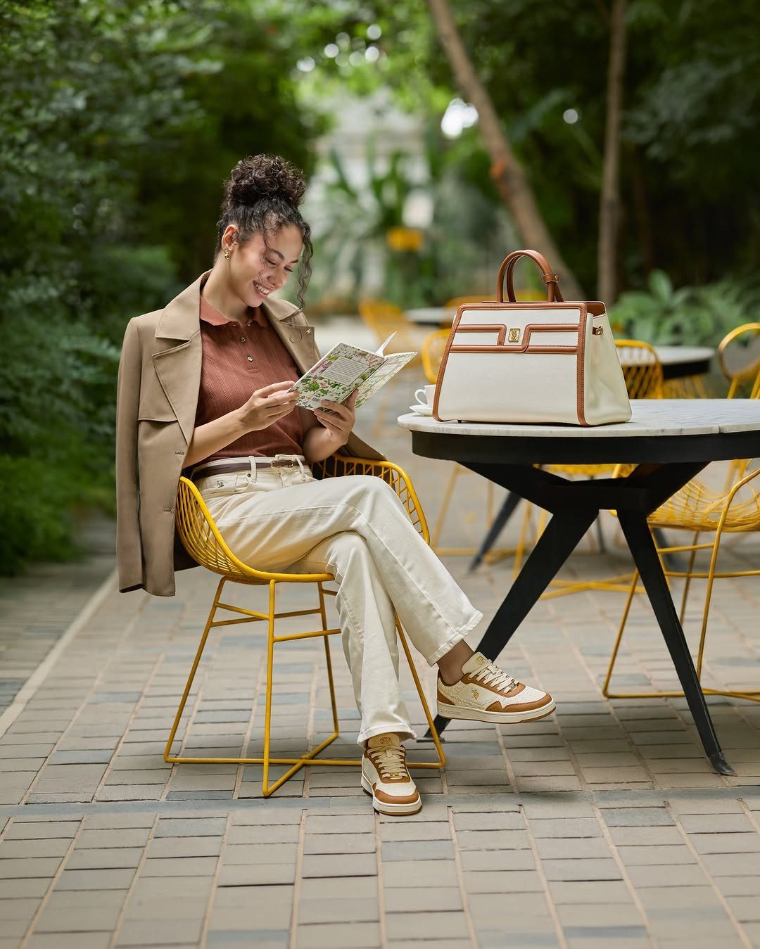 Woman in beige blazer and white pants wearing beige and white sneakers.