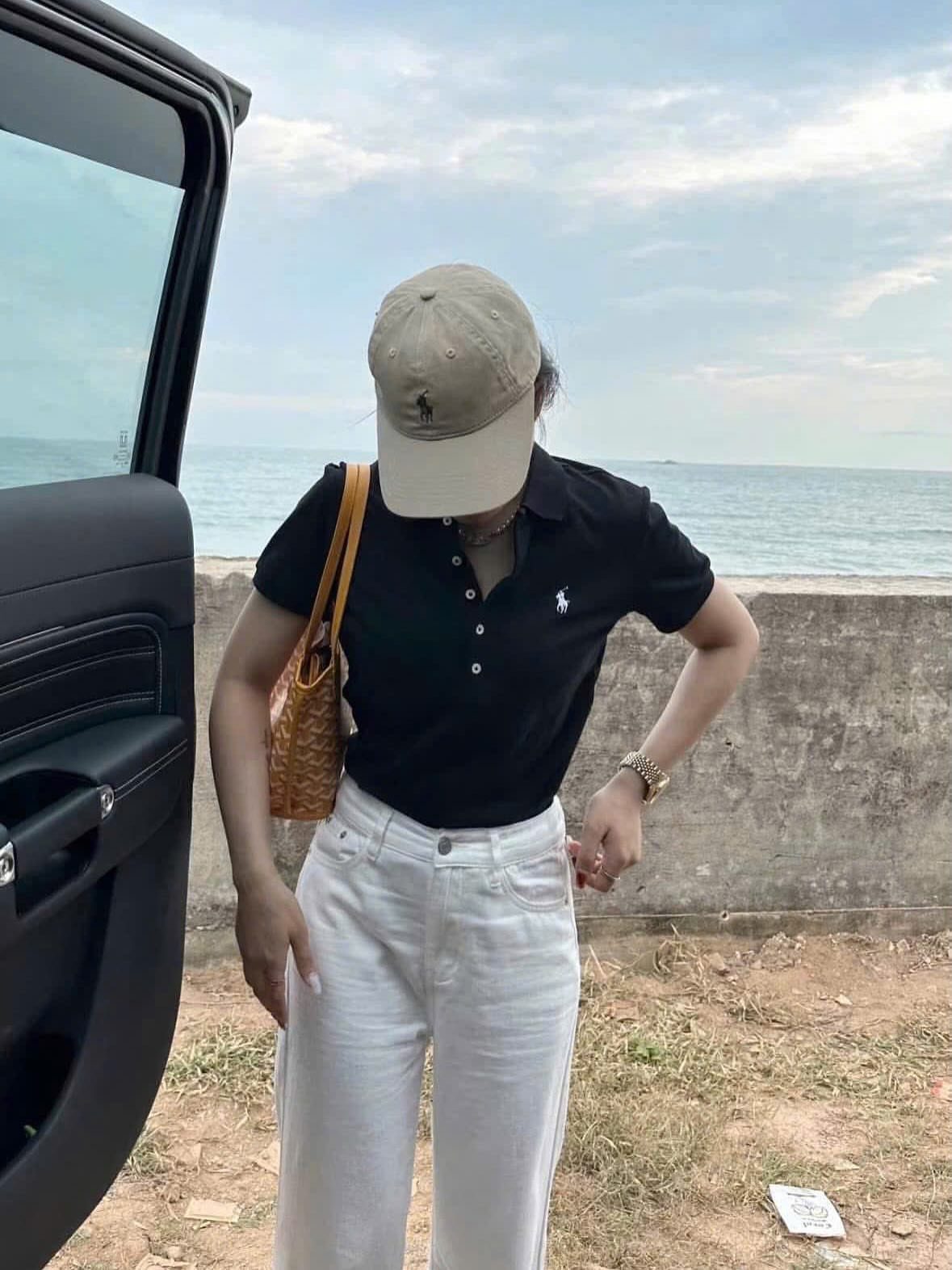 Ralph Lauren Polo Fits for Every Day: 10 Outfit Ideas 8 Person in black polo shirt, white trousers, and beige cap by the ocean.