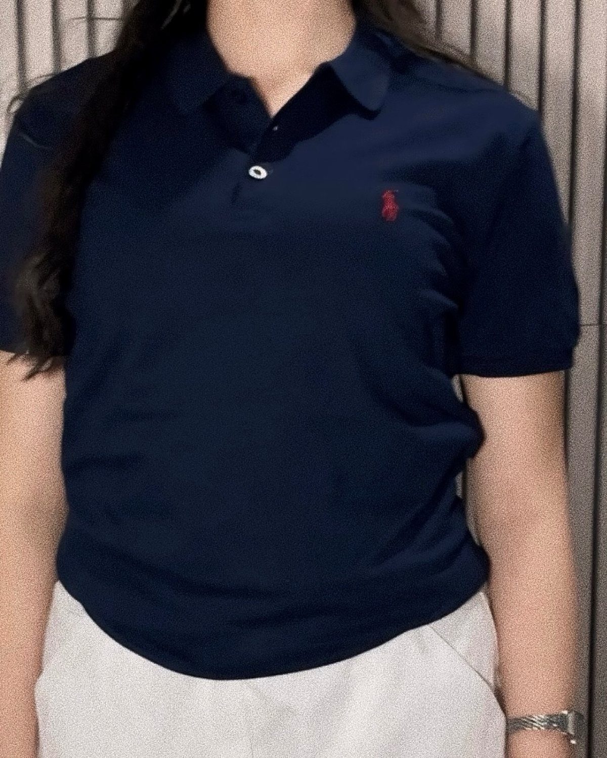 Ralph Lauren Polo Fits for Every Day: 10 Outfit Ideas 4 Person wearing a navy blue polo shirt with white trousers against a grey background