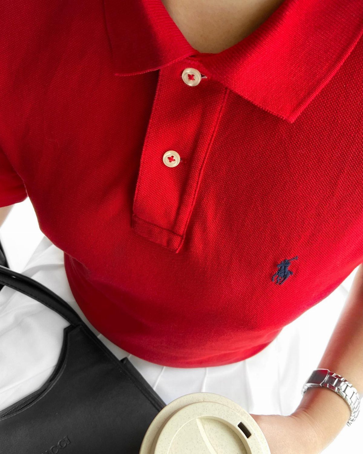 Ralph Lauren Polo Fits for Every Day: 10 Outfit Ideas 5 Red short-sleeve polo shirt with navy logo paired with white skirt and black bag.