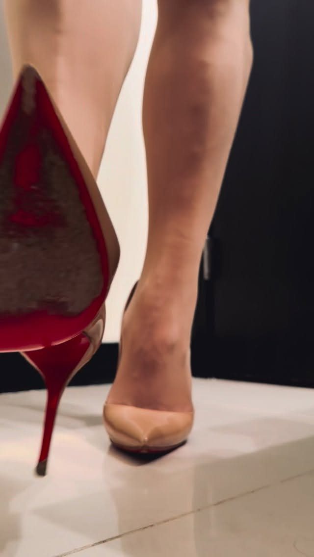 Nude pointed-toe high heels with a distinctive bright red sole and heel.