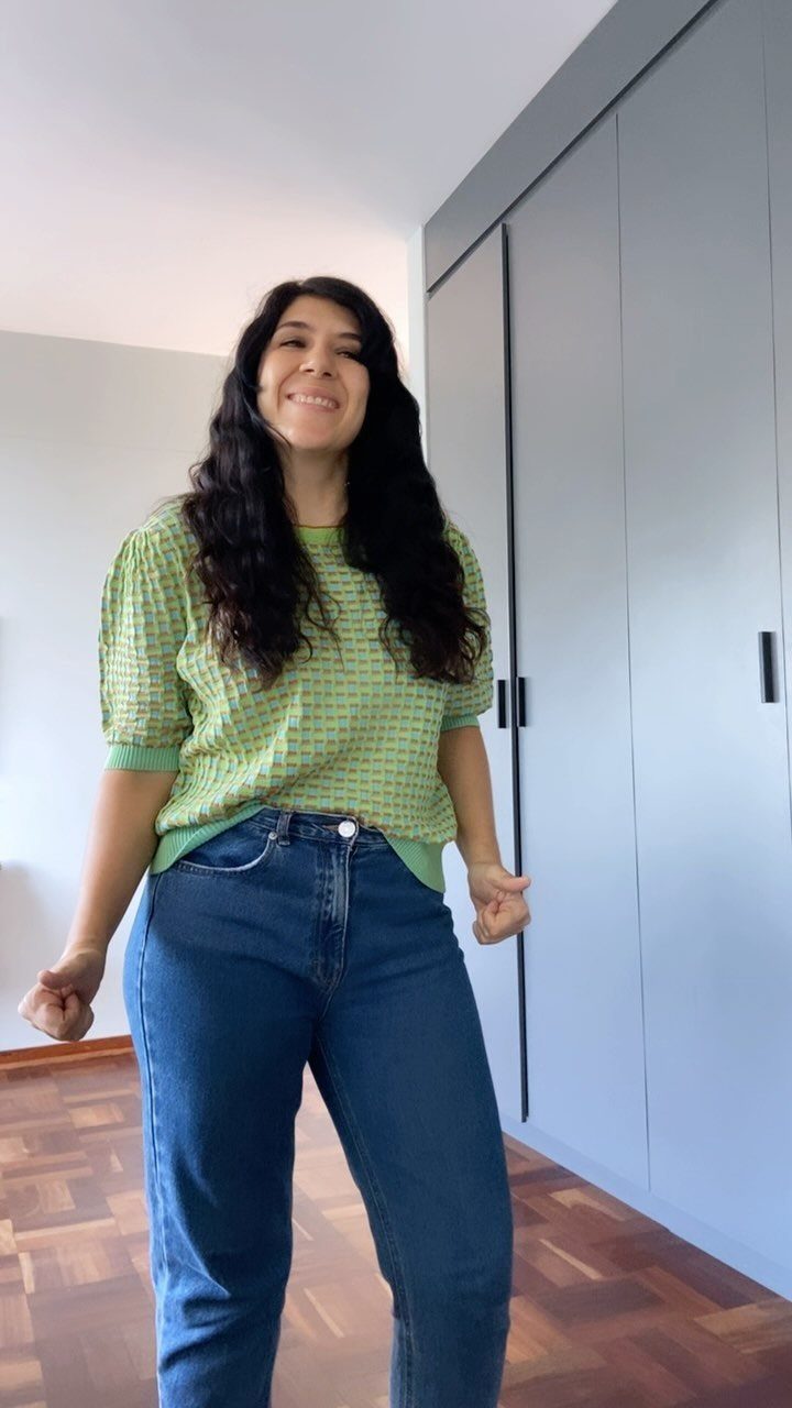 Shirt Tuck In Ideas: 4 Styles from Full Tuck to Knot 3 Woman wearing a green checkered shirt with a French tuck into blue jeans.