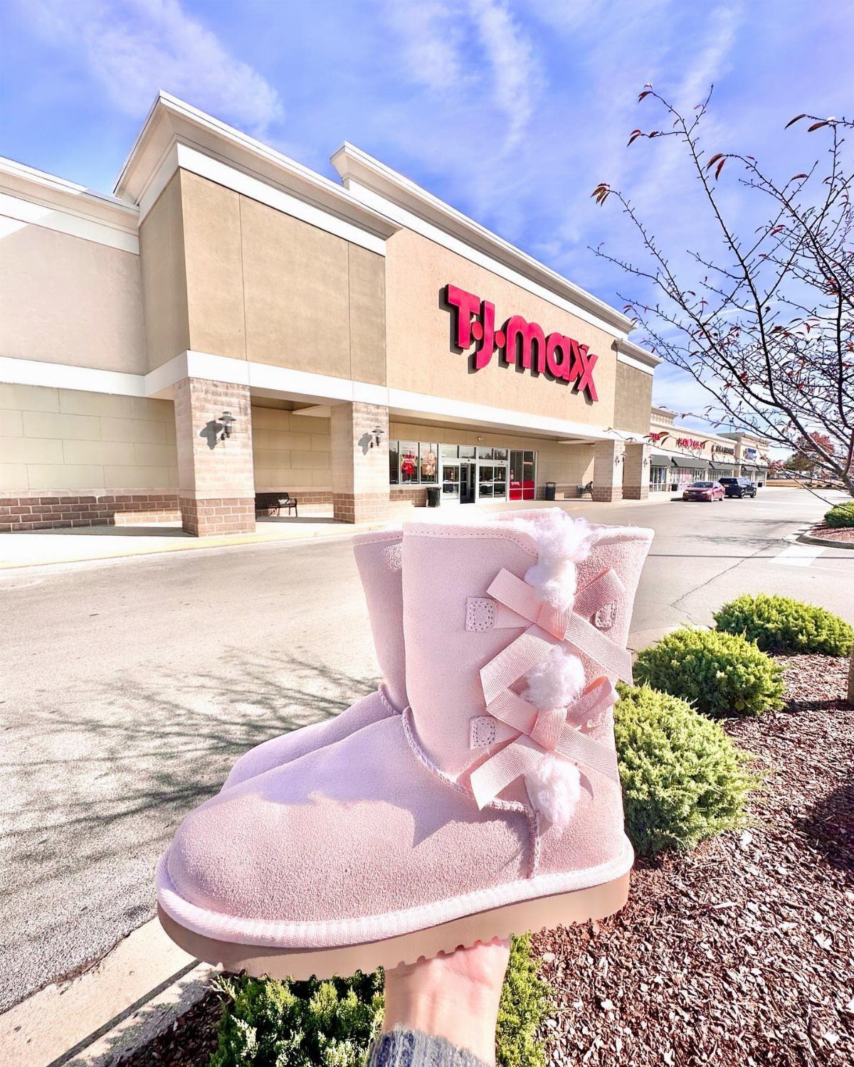 Light pink suede tall boot with a bow held in front of TJ Maxx.