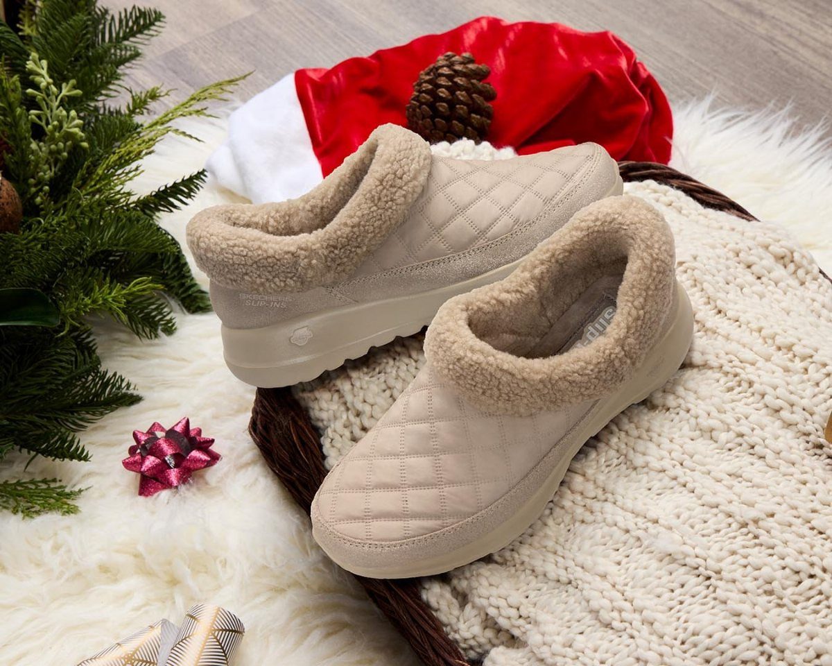 Beige quilted slipper boots with faux-fur lining on a white knit blanket.