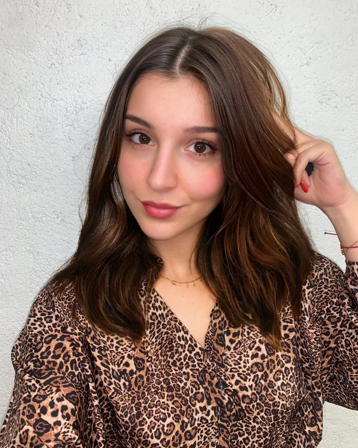 9 Soft Femme Style Ideas with Ruffles, Knits and Pearls 4 Woman with natural makeup and brown hair wearing a leopard print blouse.