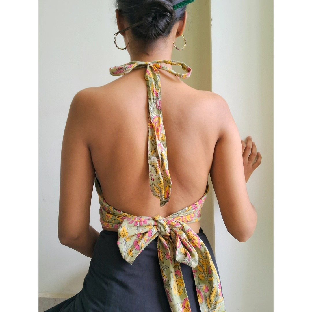 Woman wearing a patterned tie-up halter top paired with a dark grey skirt.