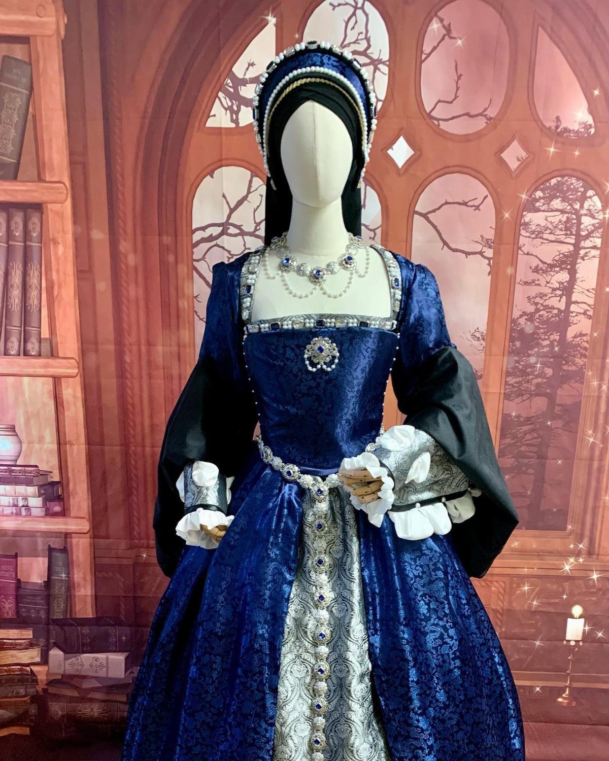 Blue and silver Tudor gown on a mannequin with a matching headpiece.