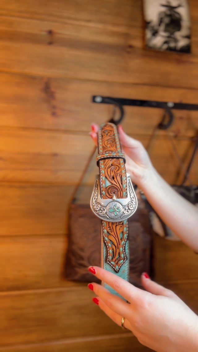 Brown leather belt with turquoise accents and a large silver ornate buckle.