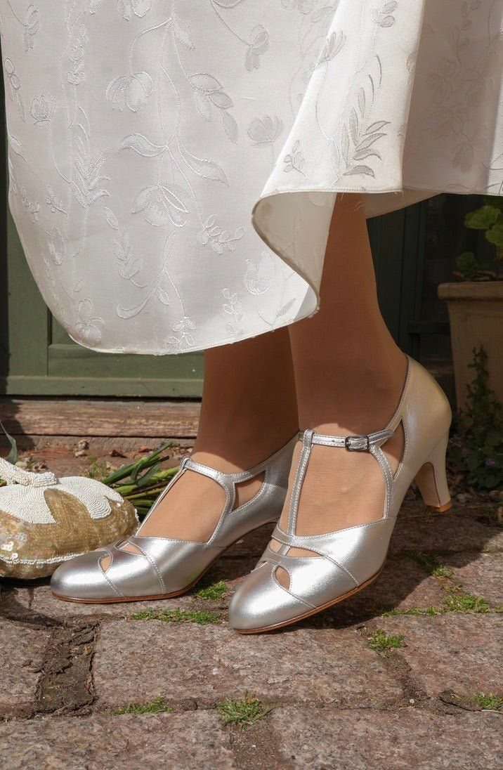 Vintage Shoes and Heels: 8 Styles From Mary Janes to Boots 2 Silver metallic T-strap block heels worn with a white floral embroidered dress.