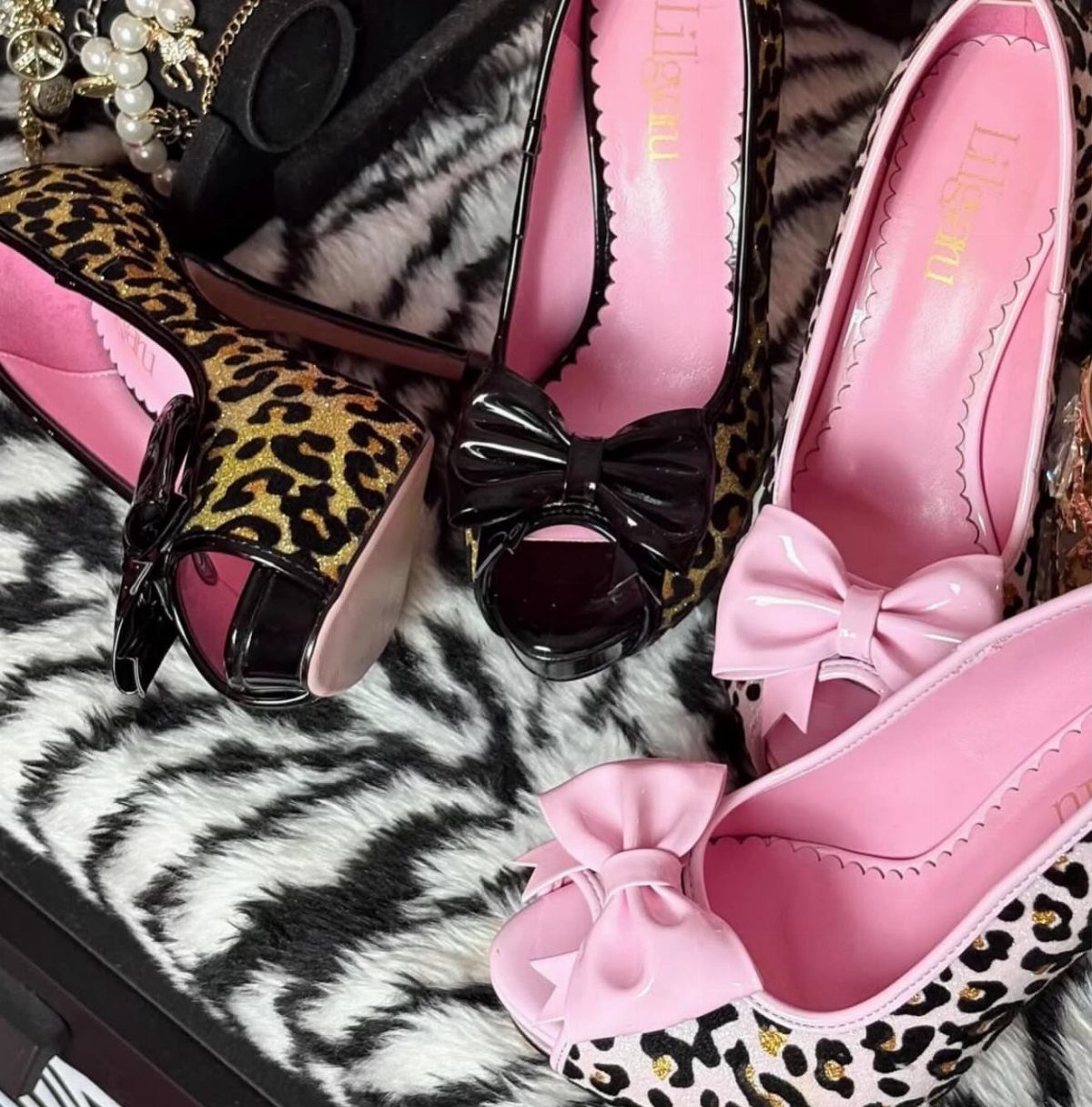 Leopard print peep toe pumps with bows on a zebra print background