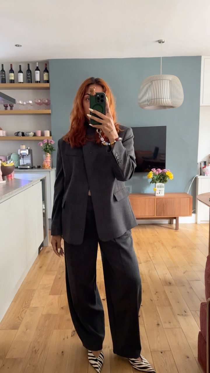 Zebra Kitten Heels: 7 Styles from Slingbacks to Mules 1 Woman in black tailored suit wearing zebra print pointed-toe kitten heels.